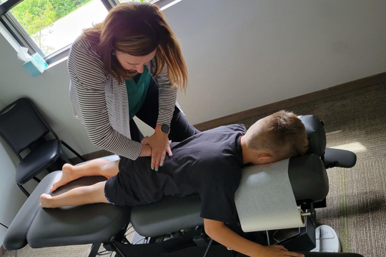 Chiropractor Kansas City MO Nichole Findell Adjusting Patient
