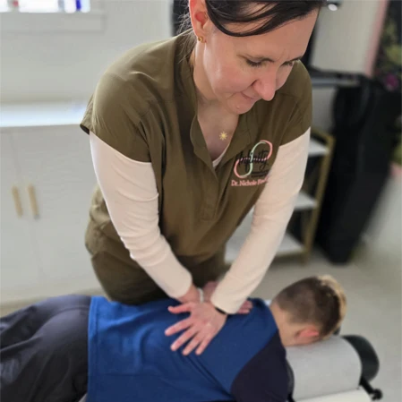 Nichole Findell Adjusting a Young Boy's Back