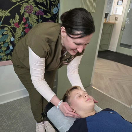 Nichole Findell Adjusting a Young Boy's Neck